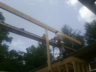 Carpenter setting a ridge beam over a new addition frame — Ice Dam Removal by Roofing Brothers in Henderson